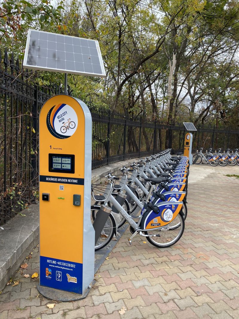 solar bike-share totem at an outdoor station, bikes docked